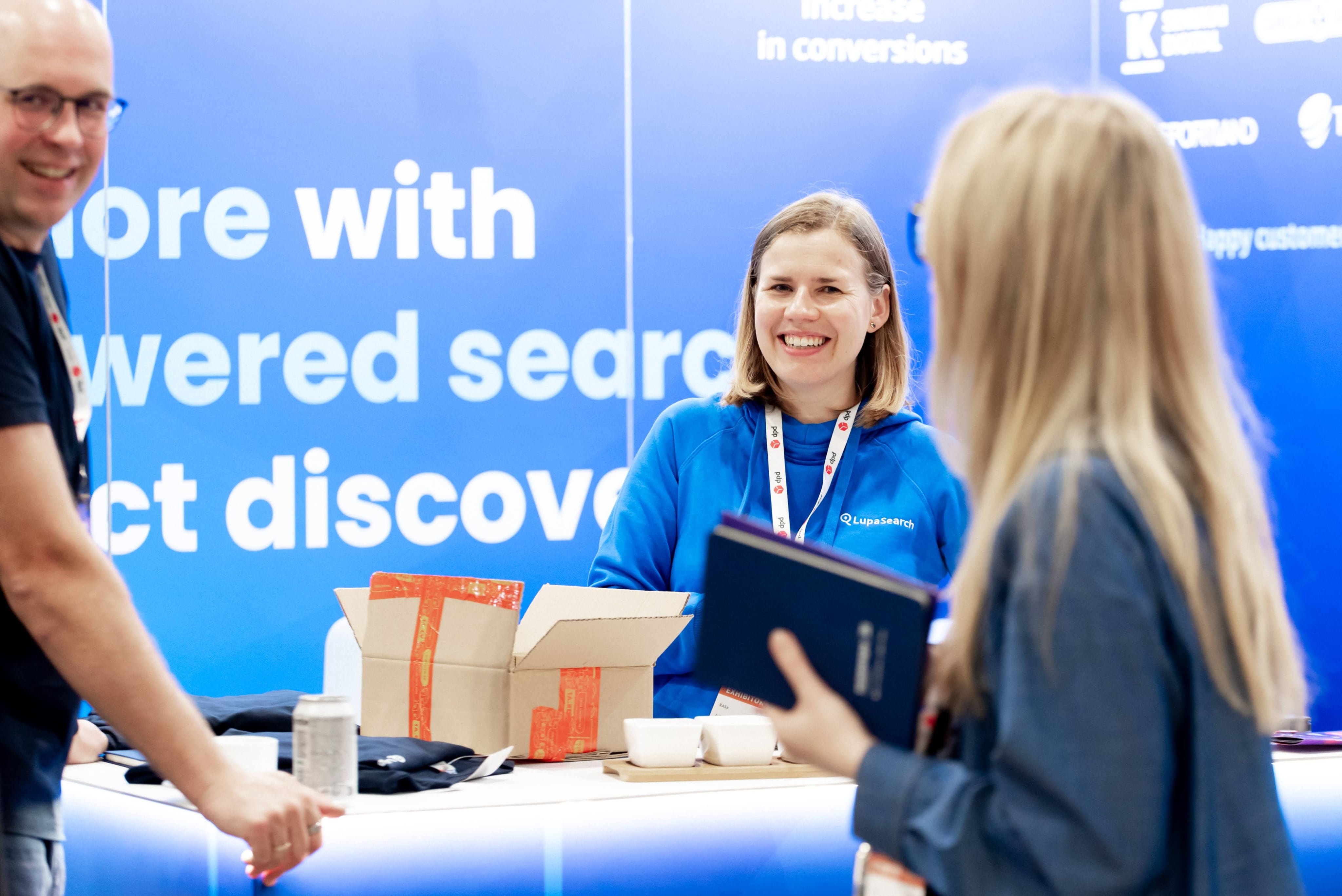 Meeting merchants and partners at events LupaSearch team member greeting visitors at an ecommerce conference booth